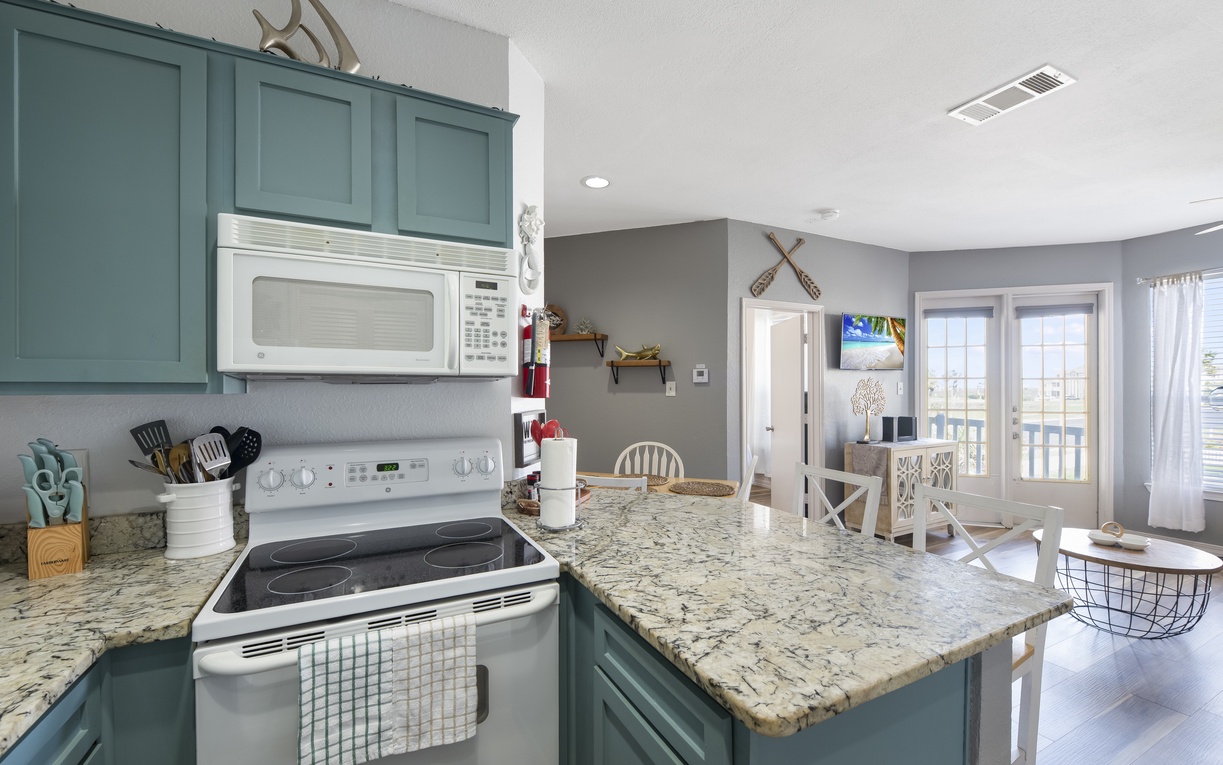 Your fully-equipped coastal kitchen features charming turquoise cabinets, granite counters, and everything you need to create memorable meals during your stay.