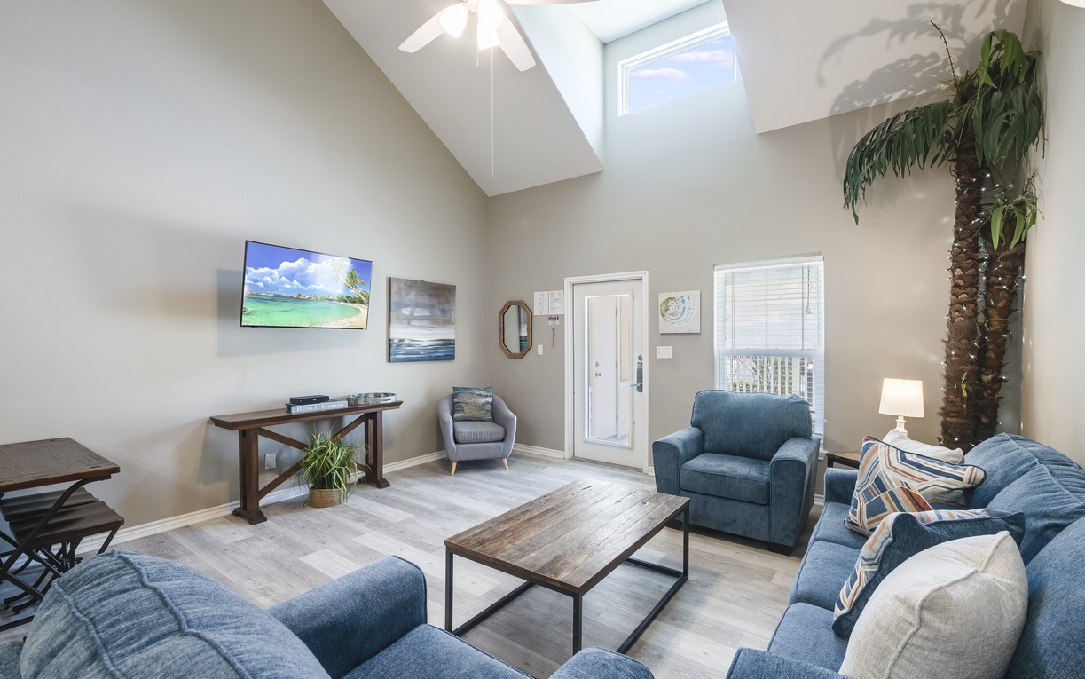 Relax in your bright, airy living room with soaring ceilings, coastal artwork, and comfortable seating perfect for unwinding after island adventures.