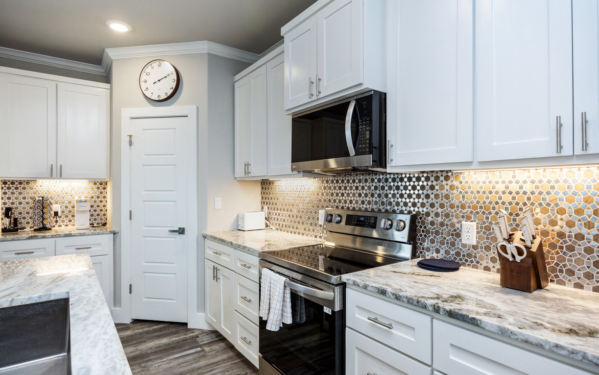 Cook your favorite meals in this bright, fully-equipped kitchen featuring granite countertops and modern appliances.