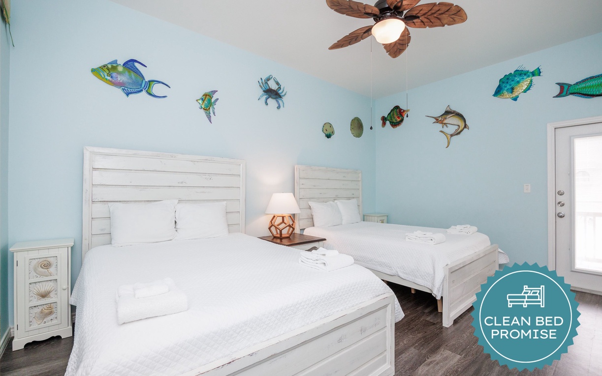 Drift off to sleep surrounded by playful sea life murals in your coastal-themed bedroom with twin beds and tropical ceiling fan.