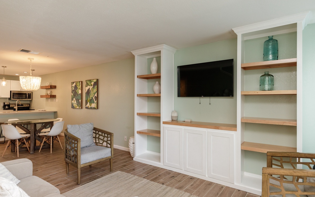 Unwind in your stylish open living space with custom built-ins, cozy seating, and seamless flow to the modern kitchen.