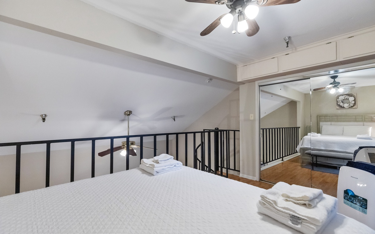 Your spacious loft bedroom features fresh linens and soaring ceilings, creating an airy retreat perfect for restful nights.