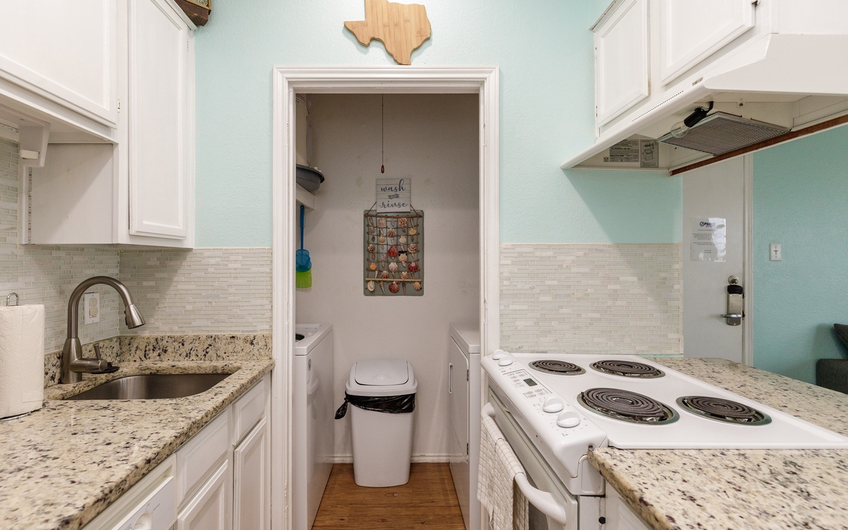 Your fully equipped galley kitchen features granite counters, white appliances, and charming Texas touches for easy meal prep.