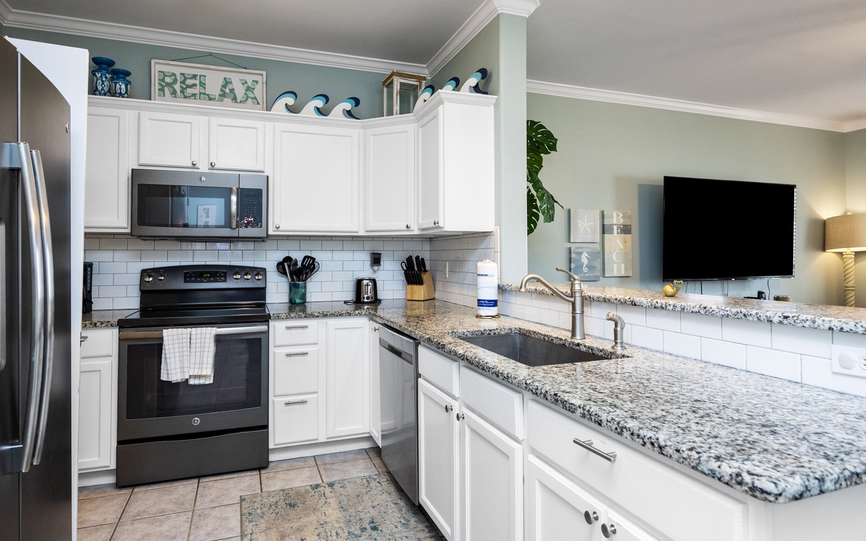 Your fully-equipped kitchen awaits with granite counters, modern appliances, and coastal charm for creating memorable vacation meals together.