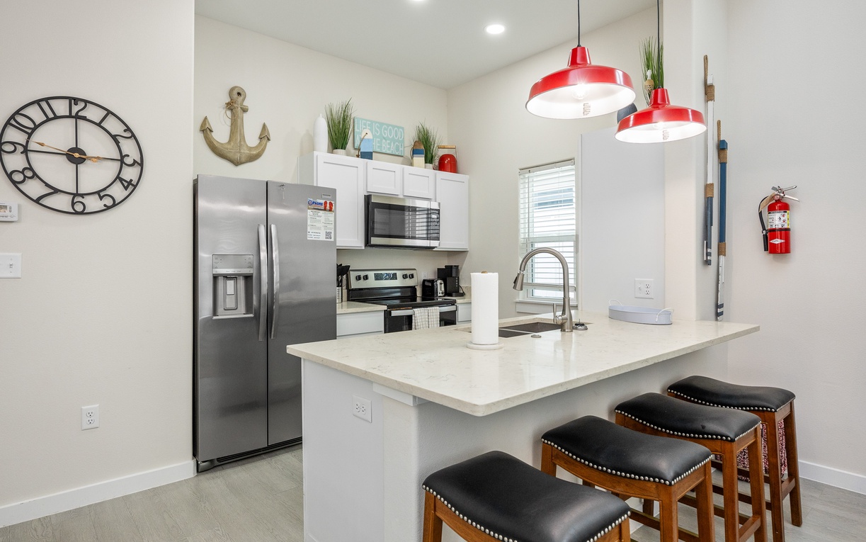 Your modern kitchen awaits with stainless steel appliances, quartz countertops, and a breakfast bar perfect for morning coffee.