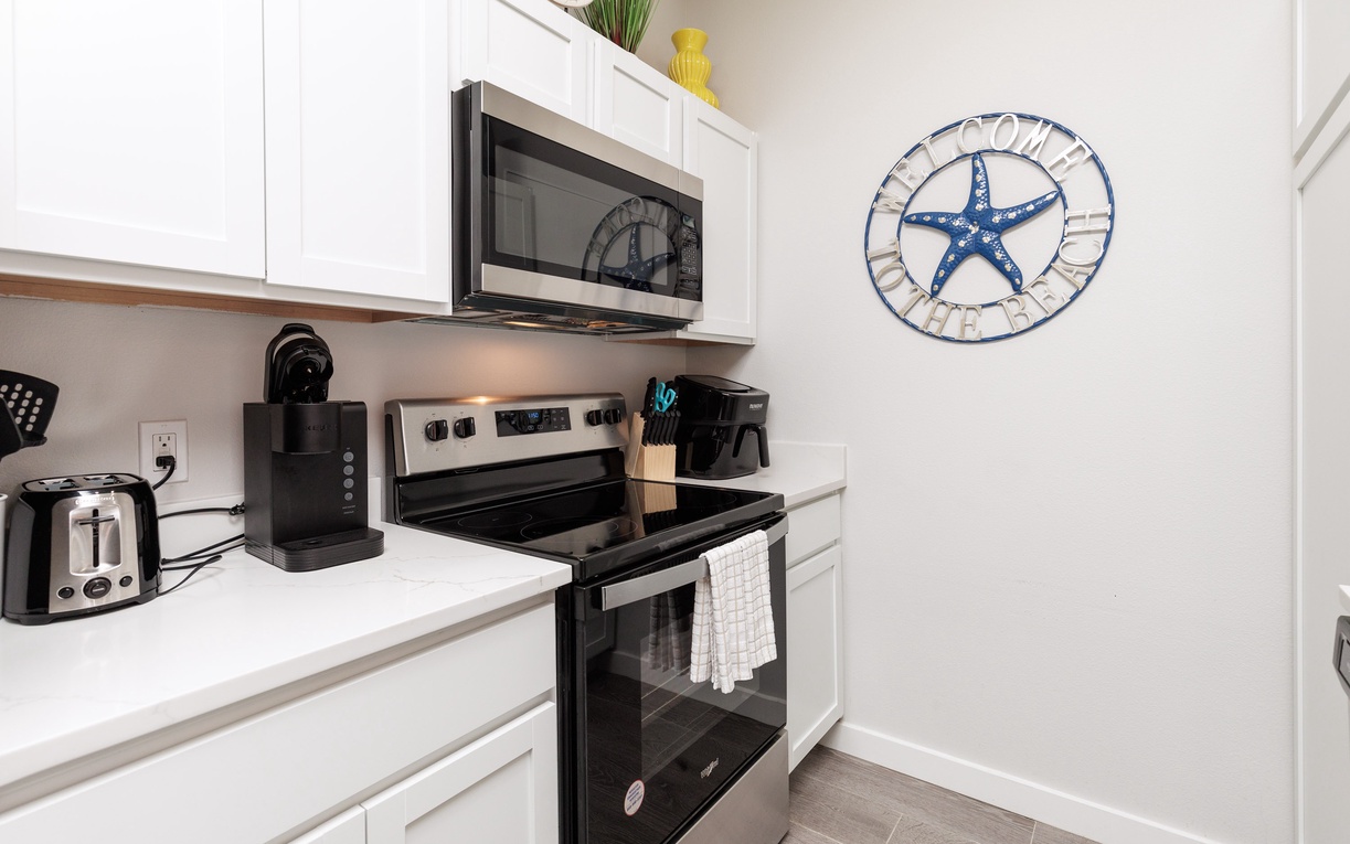 Your fully equipped kitchen makes meal prep a breeze with modern appliances and coastal charm.