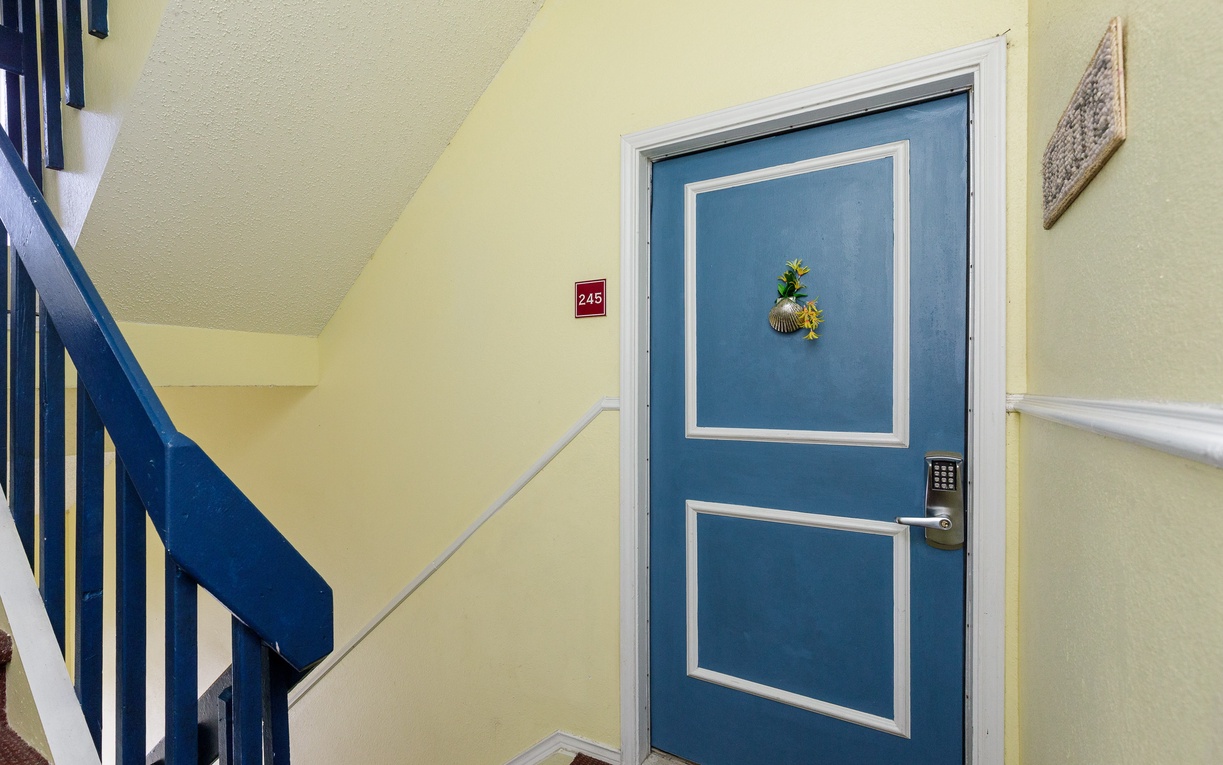 Your cheerful seaside room awaits behind this charming blue door, complete with tropical pineapple décor welcoming you home.