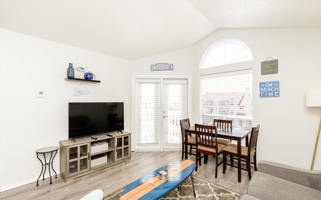 Settle into this bright open living space where beach vibes meet comfort. Your dining table awaits meals while coastal decor sets the perfect vacation mood.