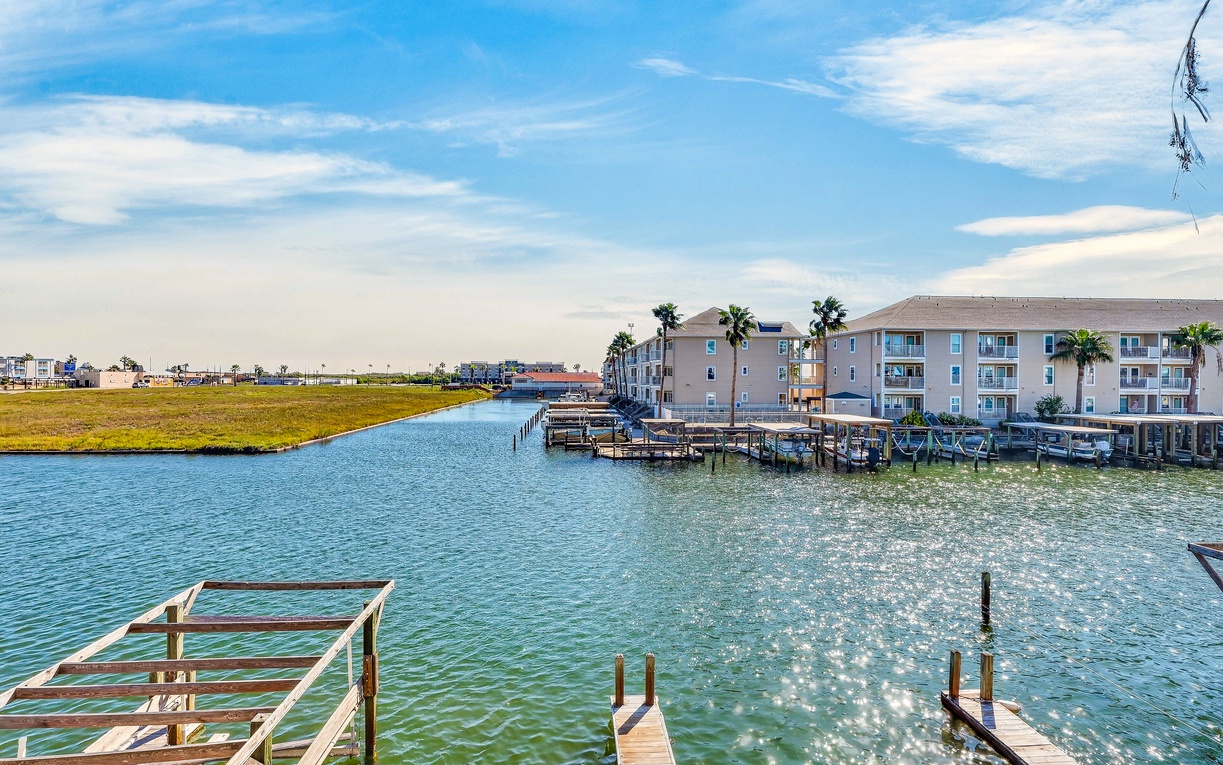 A waterfront property set along a tranquil canal with private boat docks and easy water access, surrounded by palm trees and coastal scenery.