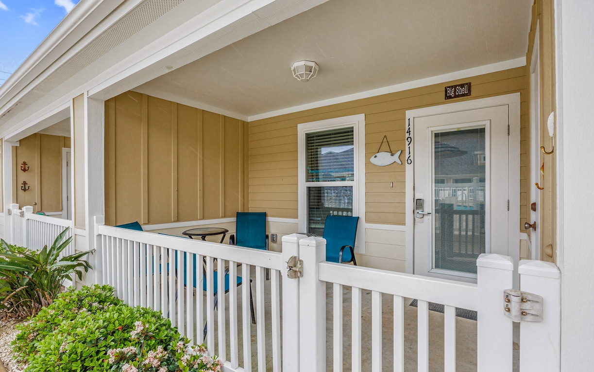 Modern coastal property entrance featuring warm wood siding and clean white trim details.