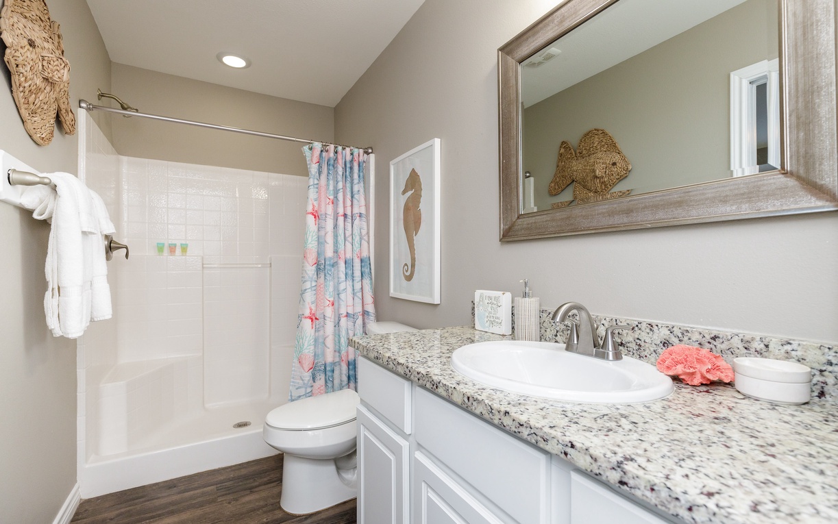Step into your coastal-themed bathroom with granite countertops, spacious shower, and charming nautical touches that make daily routines feel like a seaside retreat.