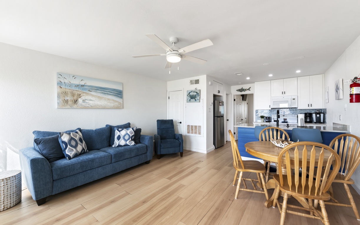 Kick back on the plush sofa or gather around the warm wood dining table in your bright, coastal-themed living space with convenient kitchen access.