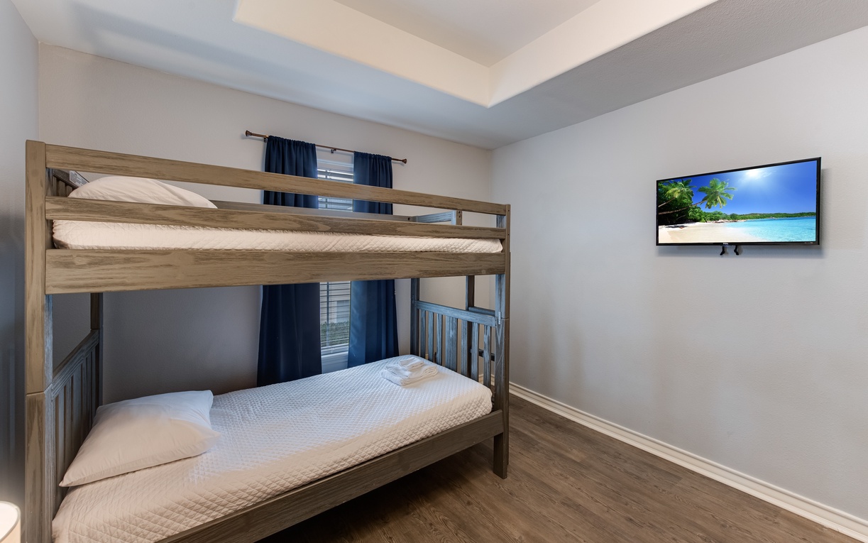 Cozy bunk room where kids can drift off watching their favorite shows on the wall-mounted TV.
