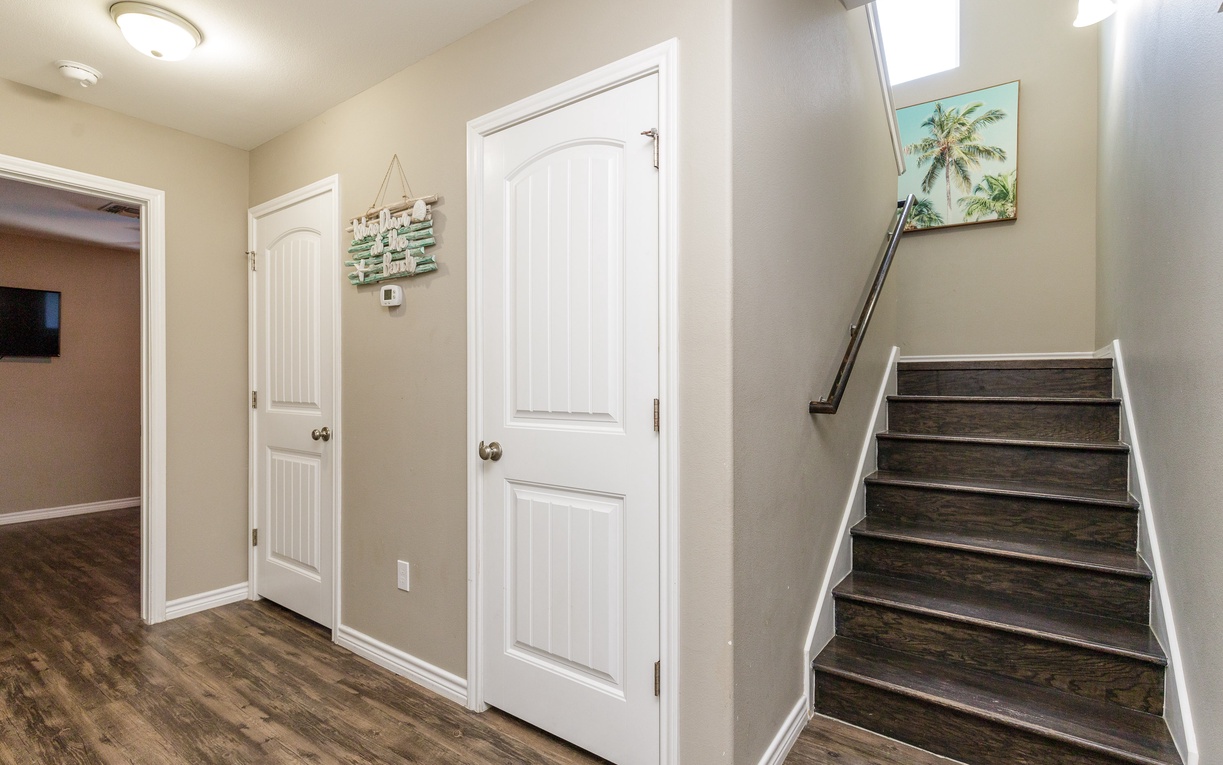 Step into your welcoming entryway with gleaming hardwood floors and bright natural light streaming through the skylight above.