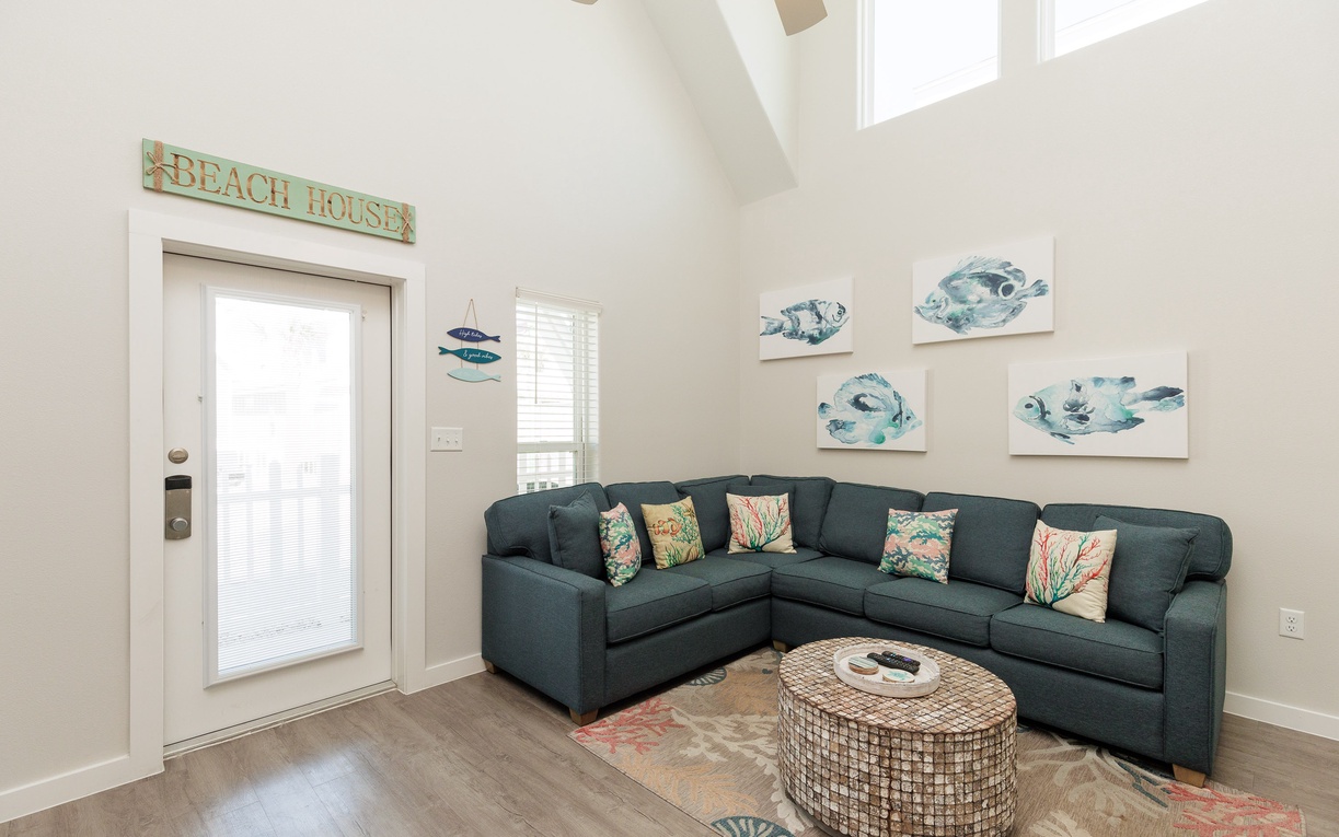 Sink into your spacious sectional sofa surrounded by coastal artwork and natural light streaming through cathedral ceilings.