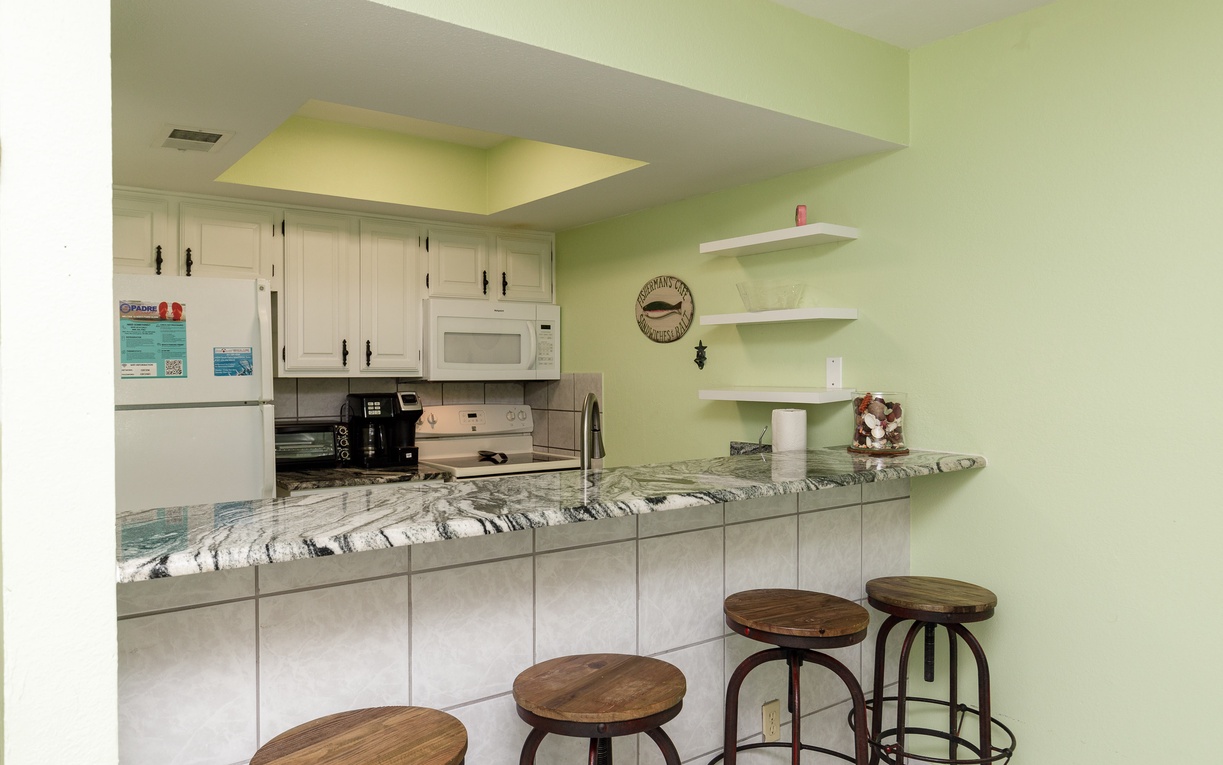 Your fully equipped kitchen features granite countertops, modern appliances, and a breakfast bar where you can start each morning with coffee.