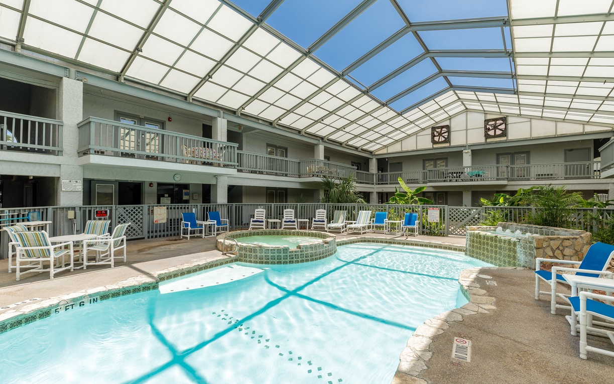 Dive into your private oasis under a stunning glass atrium, where sunlight dances on crystal-clear waters while you relax poolside.