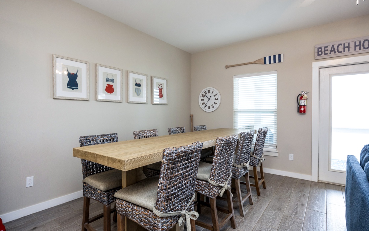 Your coastal dining space features vintage swimsuit prints and seating for eight, perfect for memorable group meals by the beach.