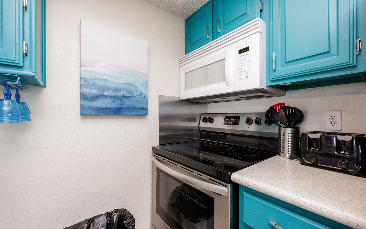 Your fully equipped kitchen features turquoise cabinets and modern appliances, creating a vibrant space where you can prepare meals with ocean-inspired charm.