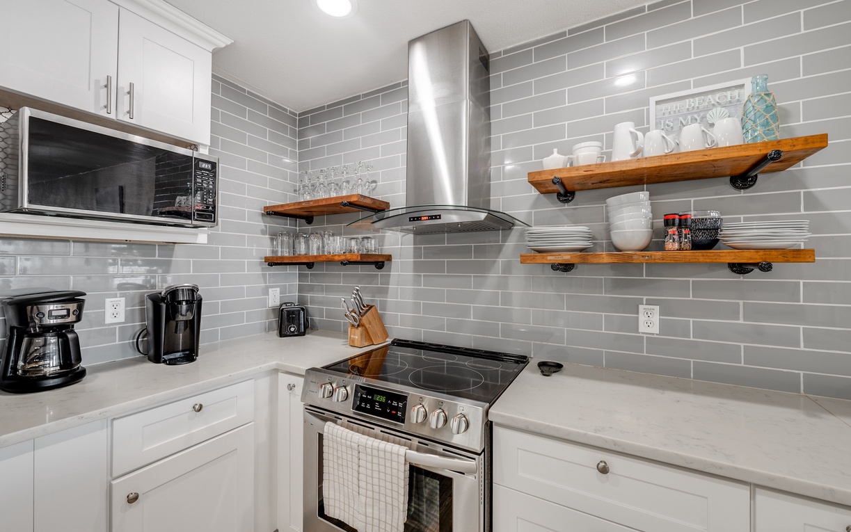 Cook your favorite meals in this stylish kitchen featuring pristine white cabinets, gleaming subway tile, and premium stainless appliances.