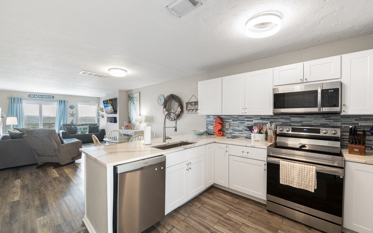 Whip up your favorite meals in this bright, fully-equipped kitchen with granite counters, stainless steel appliances, and ocean-themed touches.