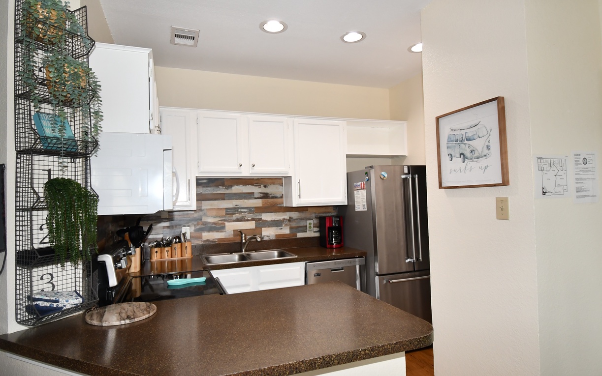 Cook your favorite meals in this fully equipped kitchen with modern appliances, granite counters, and stylish backsplash.