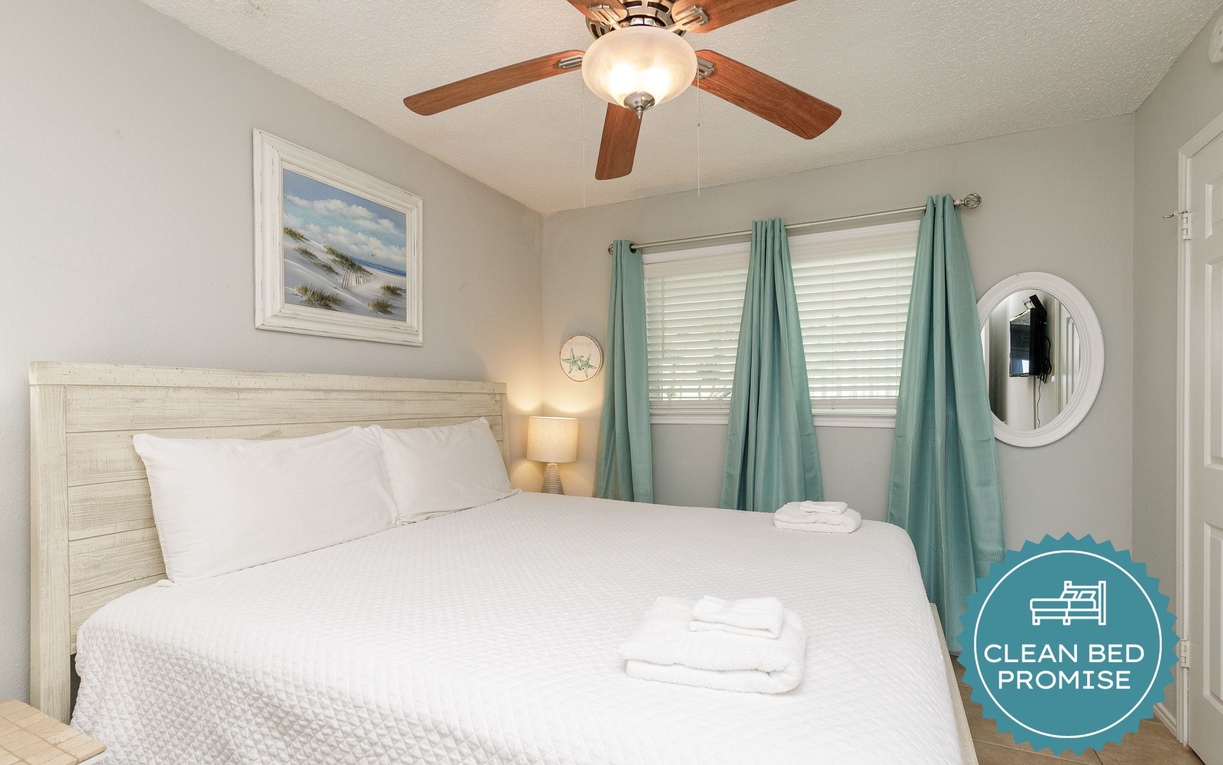 Rest easy in your coastal bedroom featuring soft linens, soothing sea-glass tones, and a gentle ceiling fan for perfect comfort.