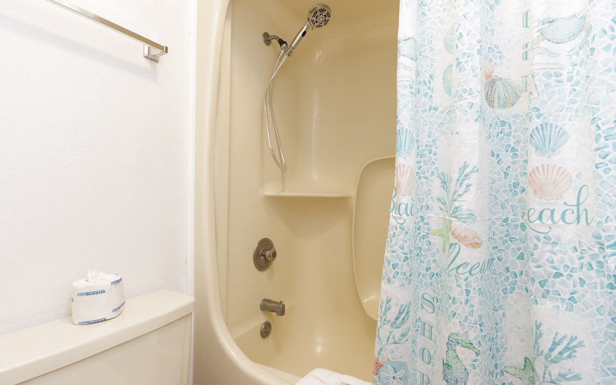 Step into your private oasis with a soothing tub/shower combo, adorned with charming ocean-themed decor that brings coastal tranquility to your daily routine.