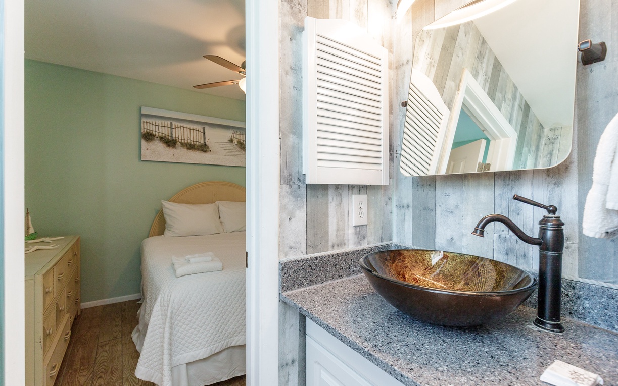 Guest bathroom connects with both bedrooms offering a coastal theme and tub/shower combo.