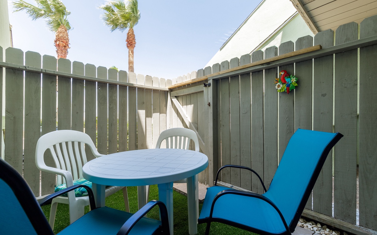 Step into your private patio sanctuary, where comfortable seating and tropical palm views create the perfect spot for morning coffee or evening relaxation.