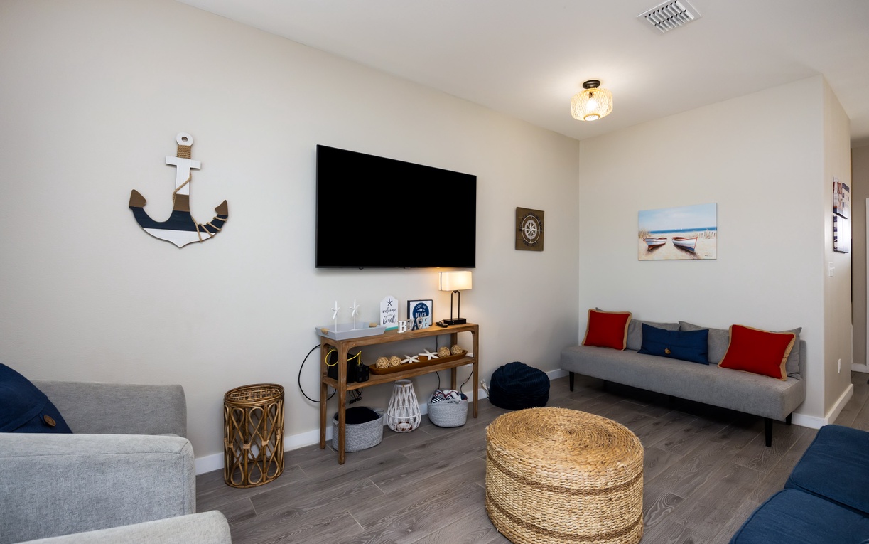 Unwind in your coastal-themed living room where nautical touches and comfy seating create the perfect space for movie nights and relaxation.