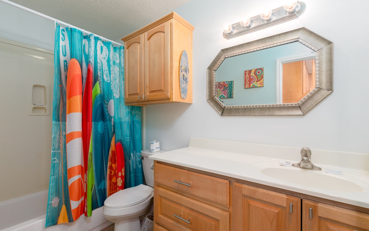 Refresh in your bright, beach-themed bathroom with colorful surf vibes and plenty of counter space for all your vacation essentials.