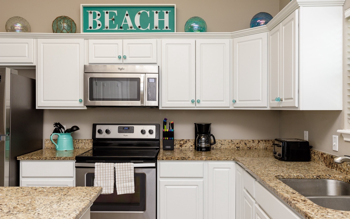 Your fully equipped kitchen awaits with granite counters, stainless appliances, and charming beach-themed decor to inspire coastal cooking adventures.