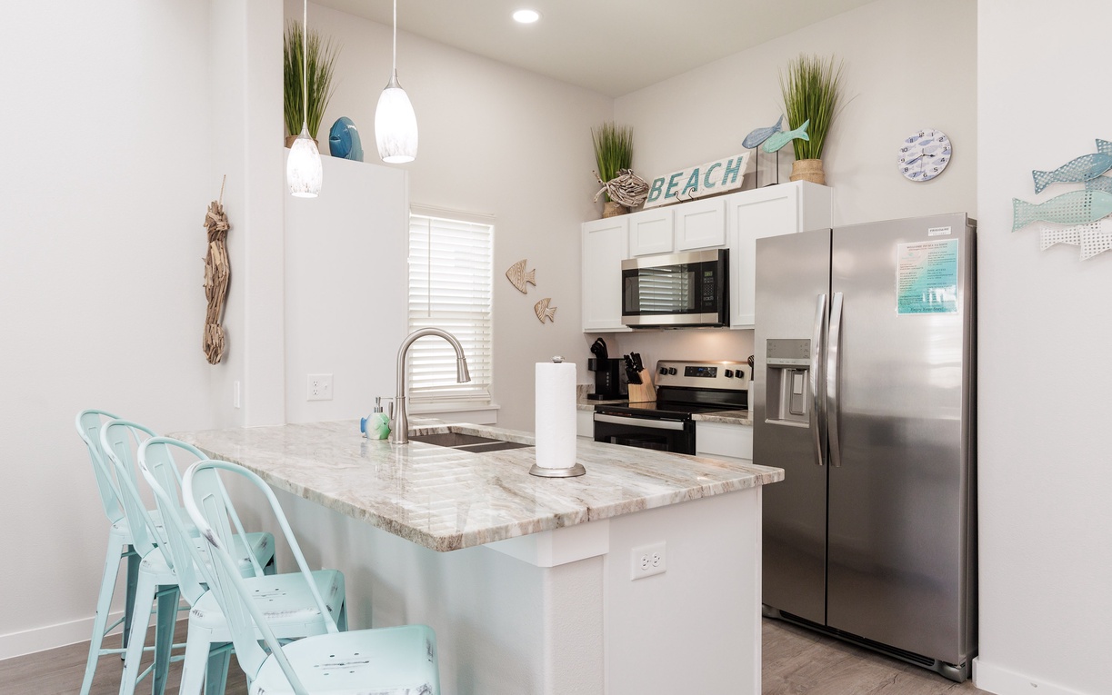 Your bright coastal kitchen invites you to whip up delicious meals with ocean-themed charm and modern conveniences at your fingertips.