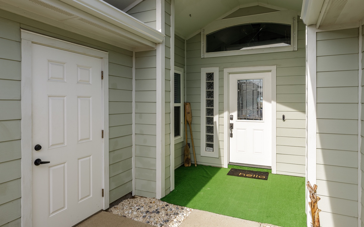 Welcoming entrance with distinctive green turf flooring and classic architectural details creates a memorable arrival experience.