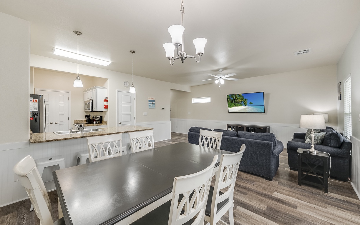 Relax in your spacious open-concept living area where the dining table flows seamlessly into the cozy living room with large TV for memorable evenings together.