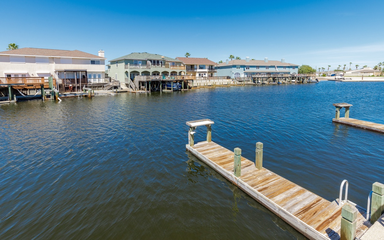Waterfront neighborhood with private docks and canal-front homes under clear blue skies.