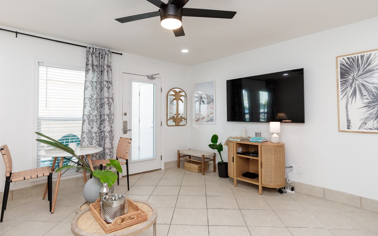 Relax in your bright living space with coastal décor, ceiling fan, and large TV for cozy evenings in.