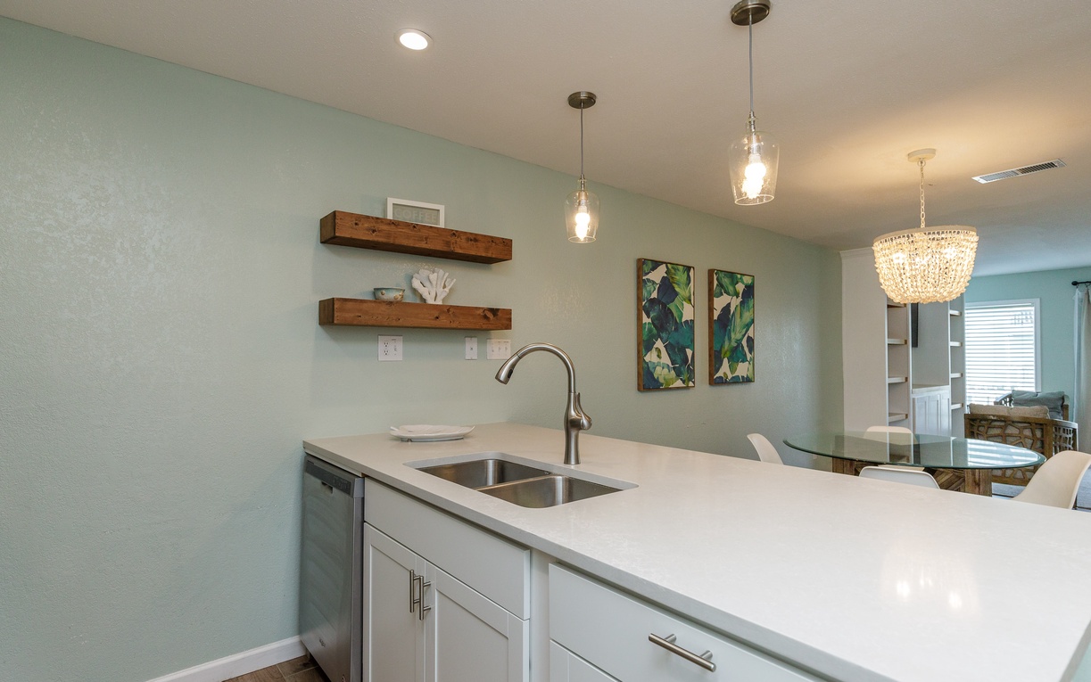 Your modern kitchen island features sleek quartz counters and pendant lighting, perfect for morning coffee or evening meal prep.
