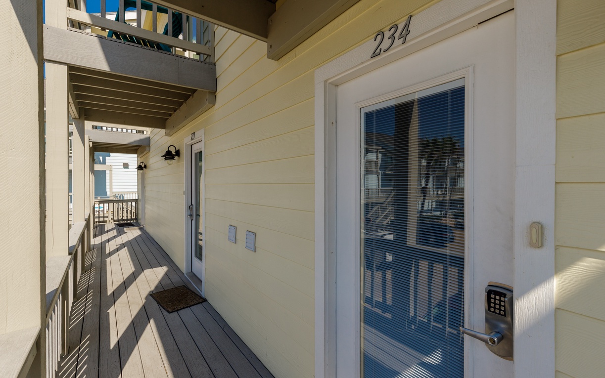 The private entrance to unit 234 welcomes you with a covered walkway and secure keypad entry for peace of mind.