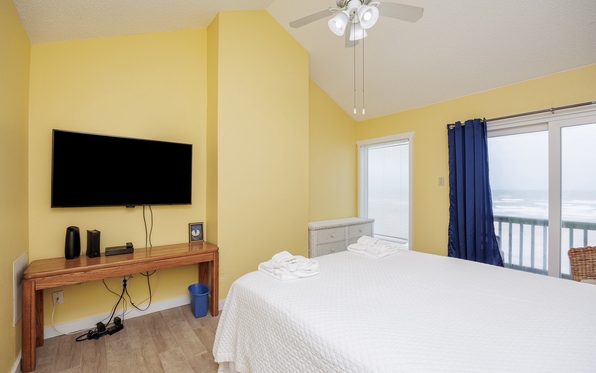 Second floor primary bedroom with queen size bed, private balcony and ensuite bathroom