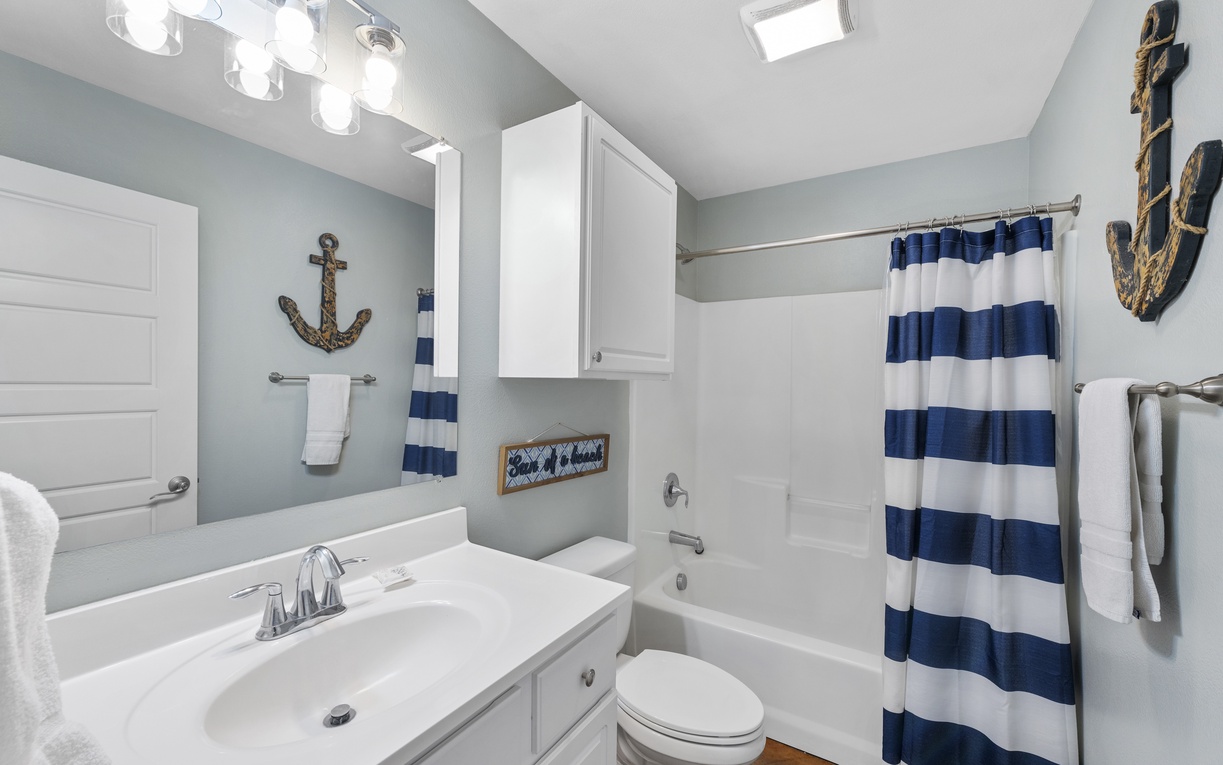 Refresh in your charming nautical-themed bathroom, complete with a soothing soaking tub and coastal decor that brings seaside serenity indoors.