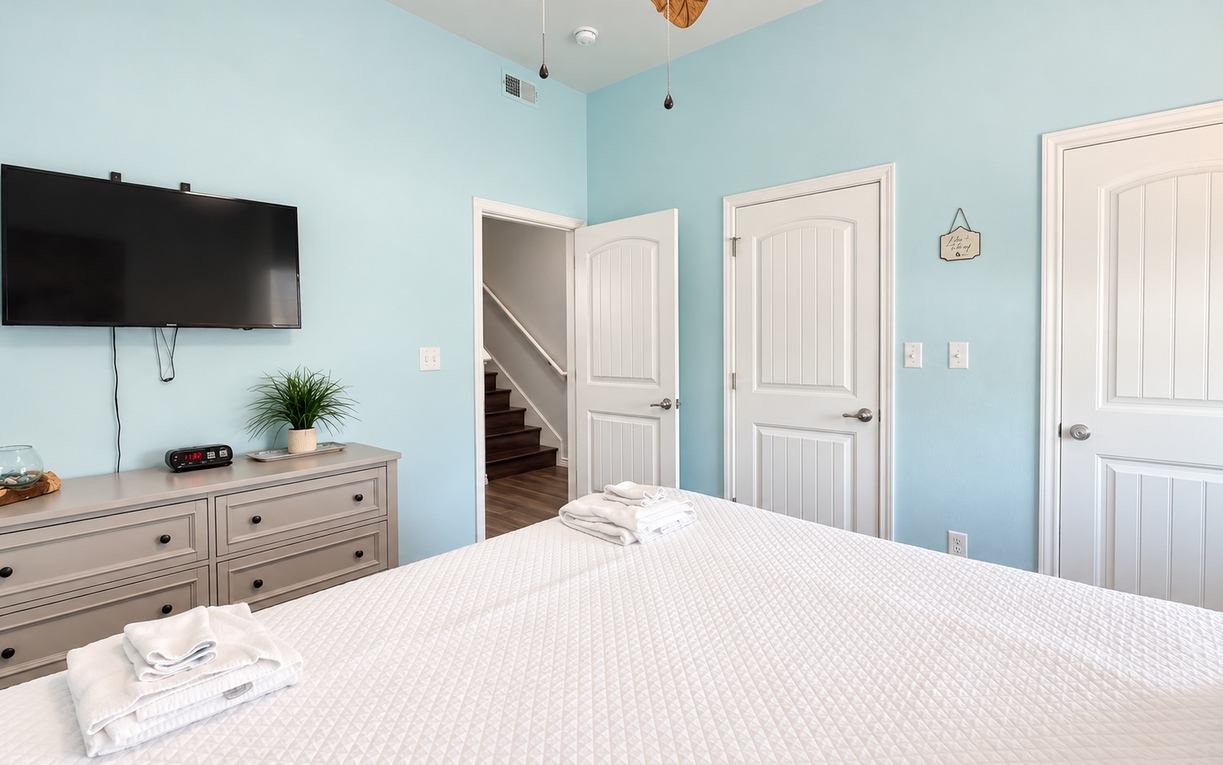 Your peaceful retreat features a plush queen bed, soothing coastal blue walls, and a wall-mounted TV for your downtime. Crisp linens and thoughtful touches await your arrival.