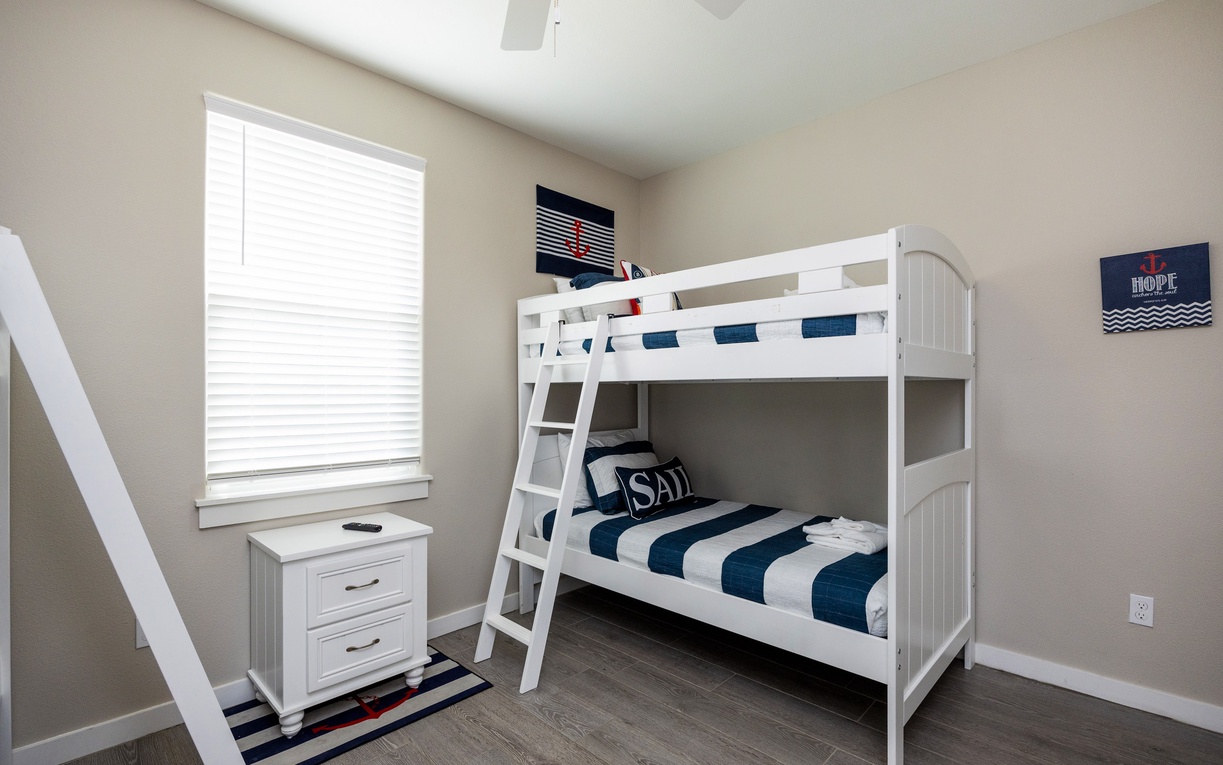 Sleep soundly in this charming nautical-themed bunk room with its crisp white beds and cheerful coastal decor.