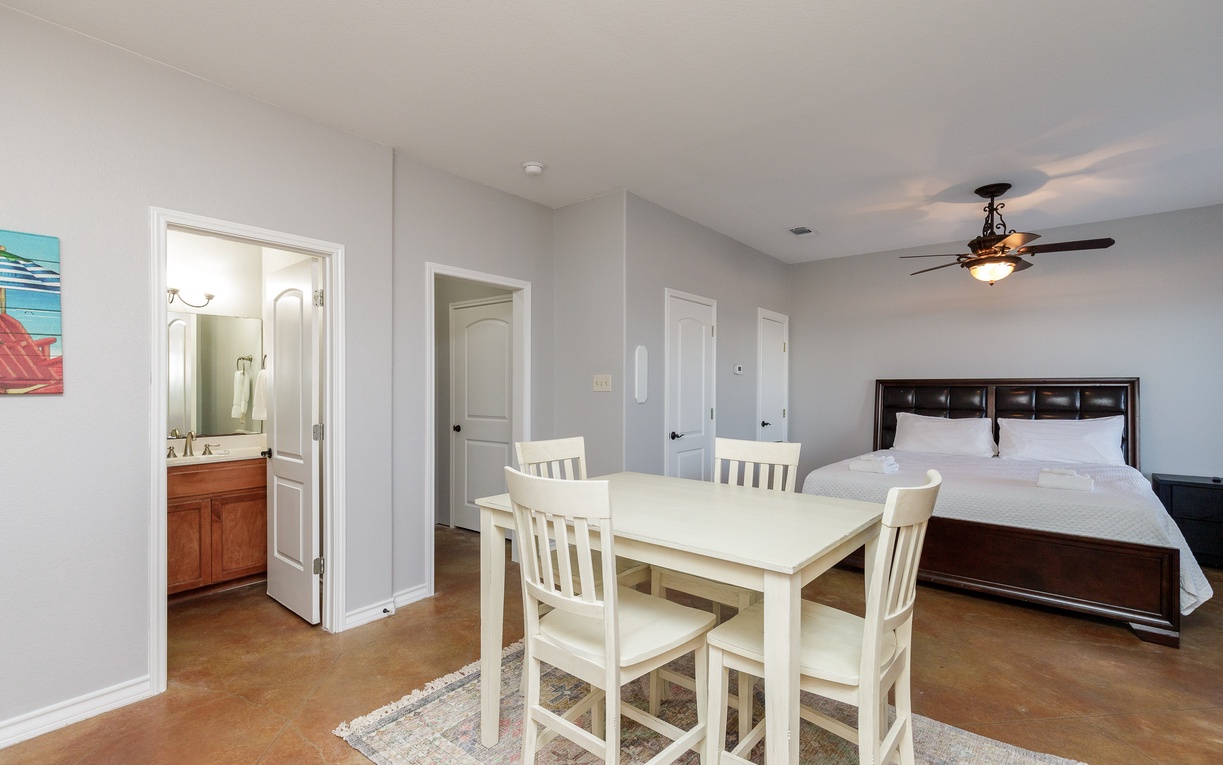 Your spacious suite combines bedroom and dining areas, with an ensuite bathroom visible through the doorway for added convenience.