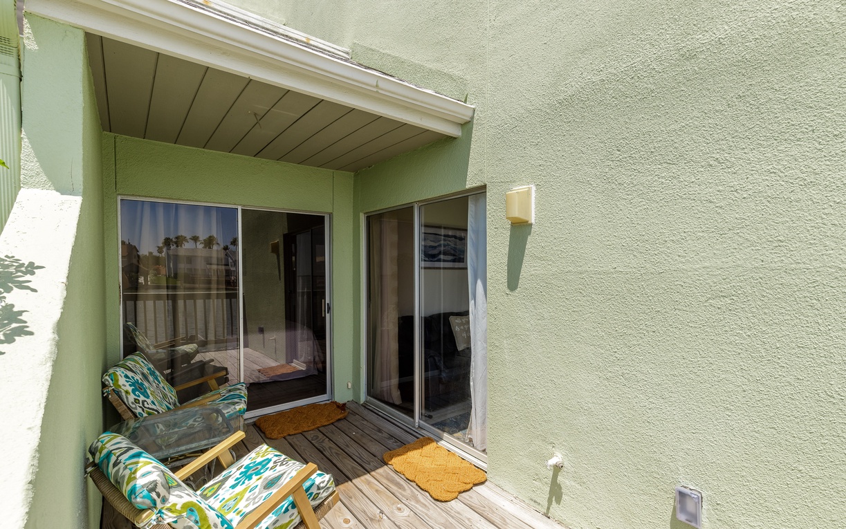 Your private covered patio features comfortable seating with colorful cushions, perfect for morning coffee or evening relaxation outdoors.