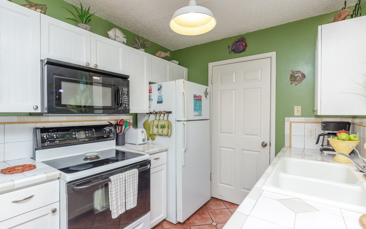Cook your favorite meals in this bright, well-equipped kitchen with modern appliances and cheerful tropical decor.