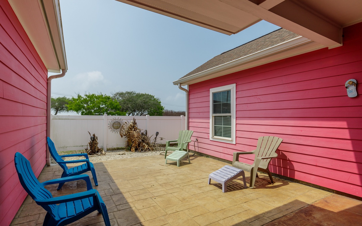 Your private patio awaits with colorful Adirondack chairs where you can unwind under the open sky and soak up the coastal sunshine.