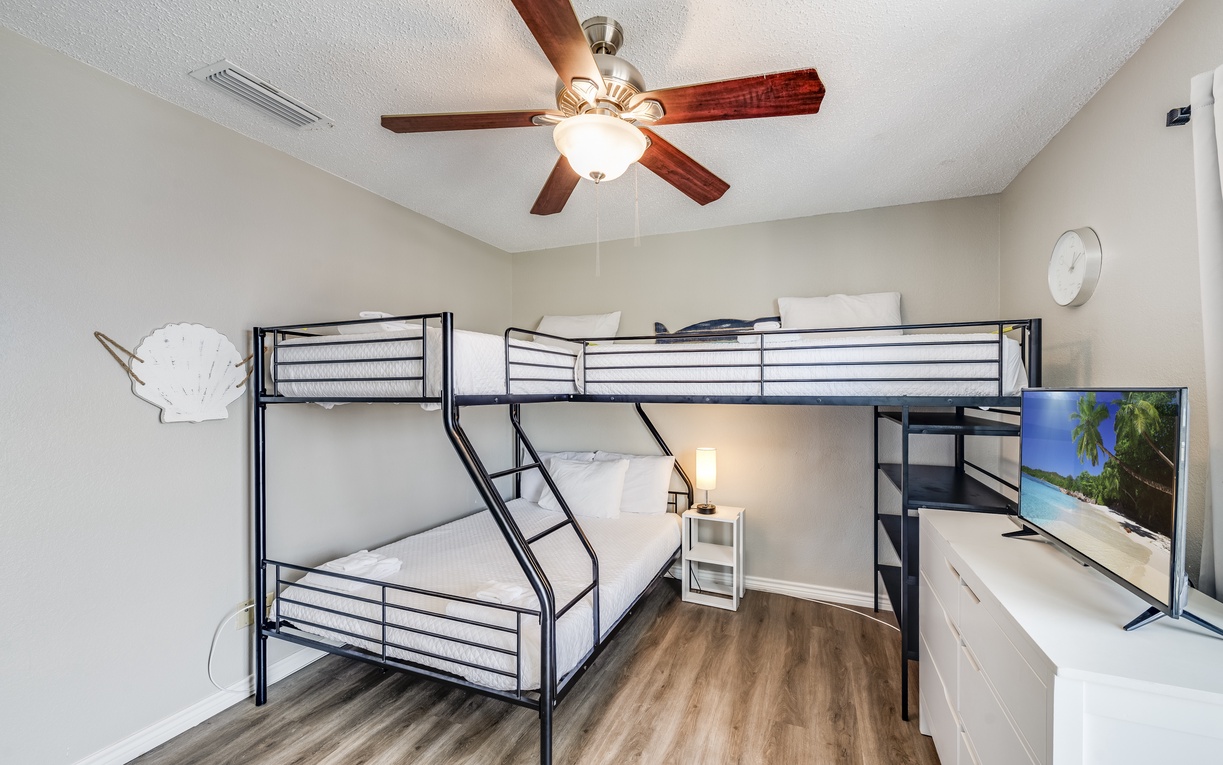 Your spacious bedroom features comfortable bunk beds, entertainment center, and ceiling fan for perfect family comfort.
