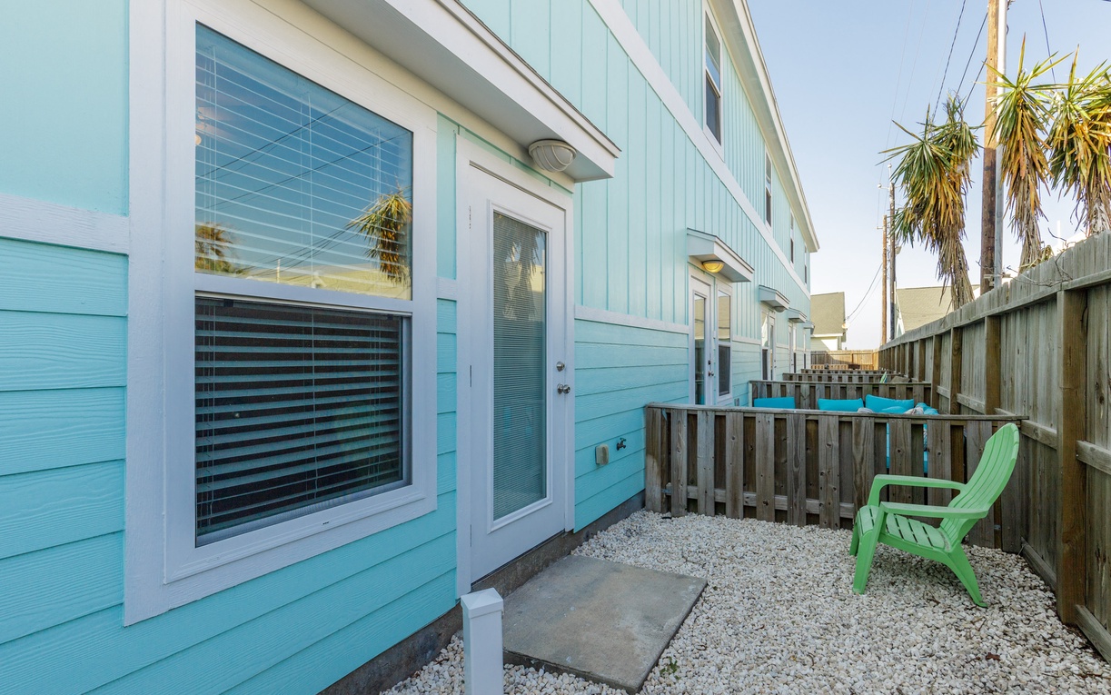 Step into your private coastal retreat with charming turquoise siding and a peaceful patio space where you can unwind.